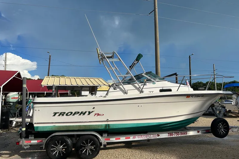 The Image of 2003 Trophy Walkaround Pro boat on trailer, parked outdoors under clear sky. - 0