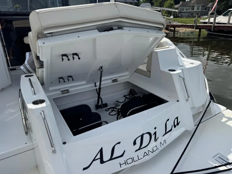 Slide: The Image of 2017 Cruisers Yachts 45 Cantius with open storage compartment, docked near waterfront homes. - 11