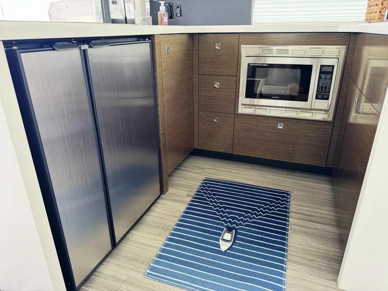 Slide: The Image of 2017 Cruisers Yachts 45 Cantius kitchen with stainless steel fridge and microwave. - 17