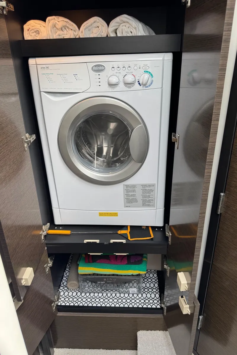 Slide: The Image of Compact laundry area with washer in 2017 Cruisers Yachts 45 Cantius, towels neatly stored above. - 35