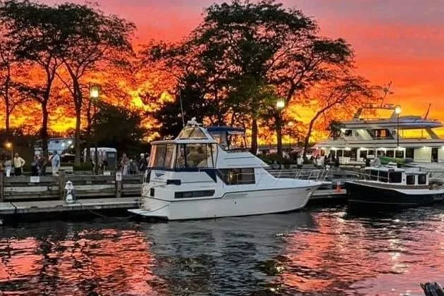 The Image of 1994 Carver 350 yacht docked at sunset, vibrant sky reflecting on water. - 0