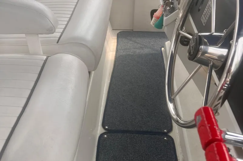 Slide: The Image of Interior of 1994 Carver 350 boat with steering wheel and white seating. - 15