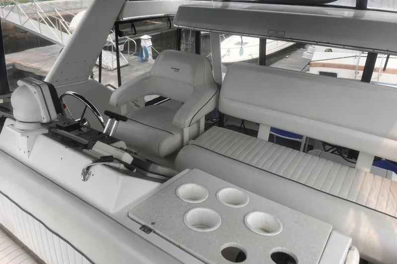 Slide: The Image of 1994 Carver 350 yacht interior with white seating and steering wheel, docked at marina. - 19