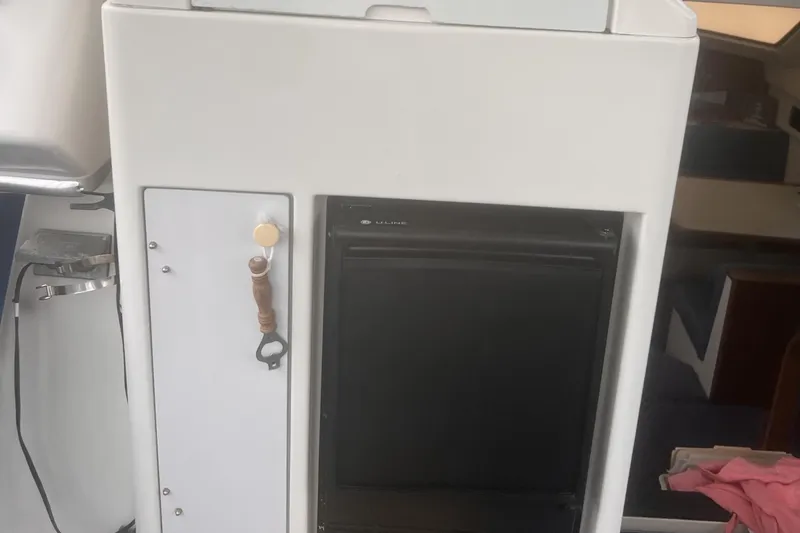 Slide: The Image of 1994 Carver 350 interior with compact fridge and storage compartment. - 23