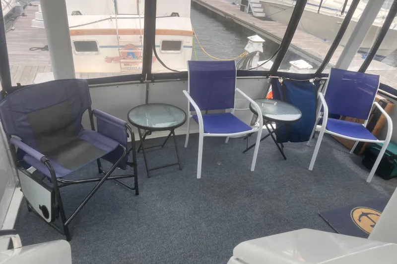 Slide: The Image of 1994 Carver 350 boat interior with blue chairs and glass tables on a carpeted deck. - 27