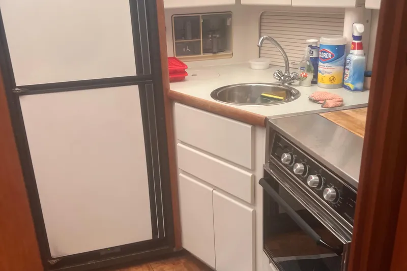 Slide: The Image of 1994 Carver 350 yacht kitchen with stove, sink, and refrigerator. - 36