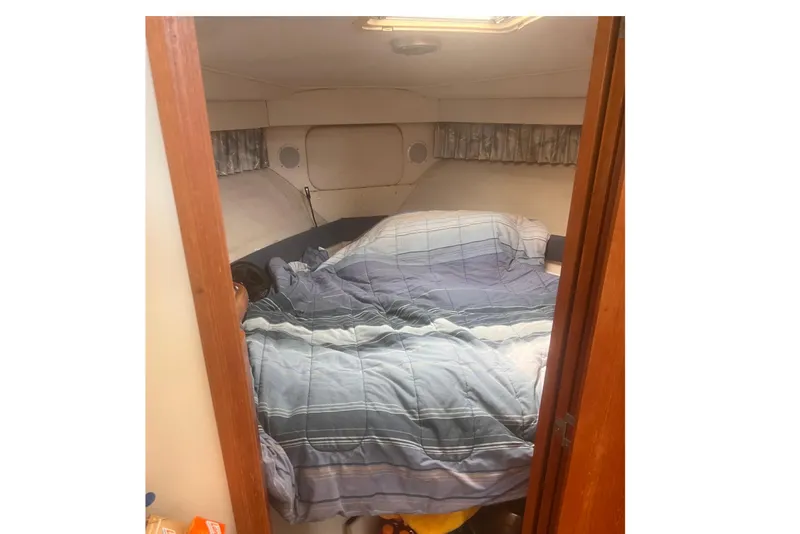 Slide: The Image of 1994 Carver 350 cabin interior with cozy bed and plaid bedding. - 42