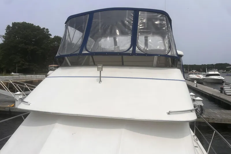 Slide: The Image of 1994 Carver 350 yacht docked at marina, featuring a clear canopy and sleek design. - 6