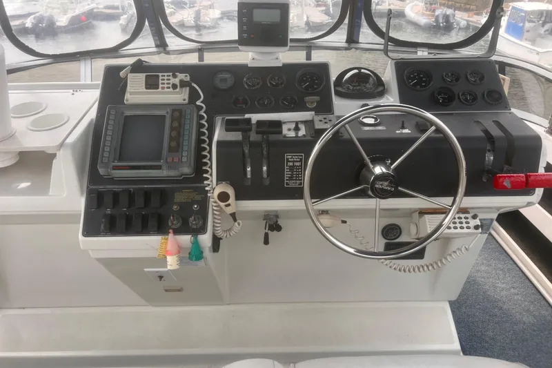 Slide: The Image of 1994 Carver 350 boat helm with steering wheel, gauges, and navigation equipment. - 10