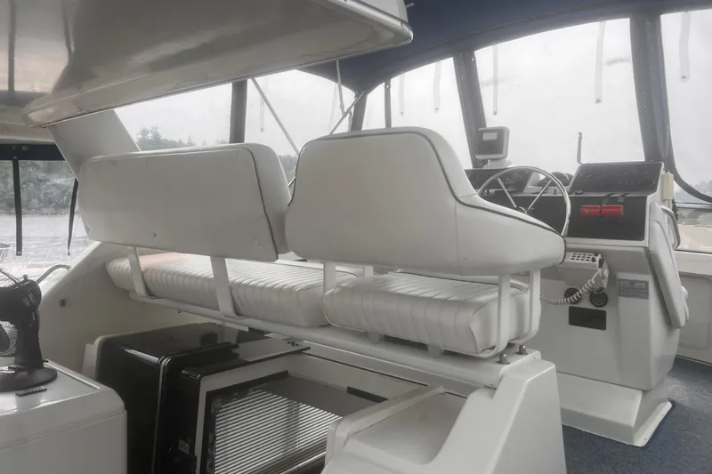 Slide: The Image of Interior of a 1994 Carver 350 boat with white seating and steering console. - 21