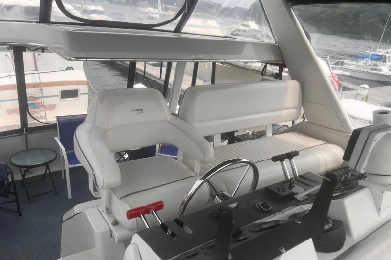 Slide: The Image of 1994 Carver 350 yacht interior with helm, white seating, and marina view. - 22