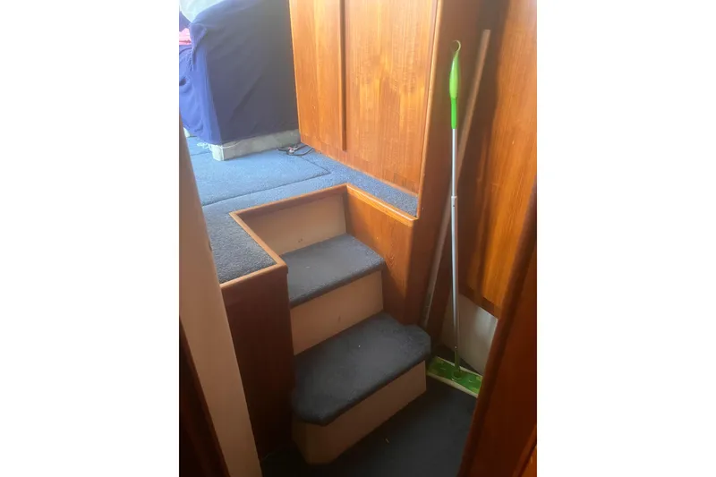 Slide: The Image of Interior stairs of a 1994 Carver 350 boat with wooden paneling. - 28