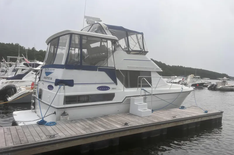 Slide: The Image of 1994 Carver 350 yacht docked at a marina, surrounded by other boats. - 4