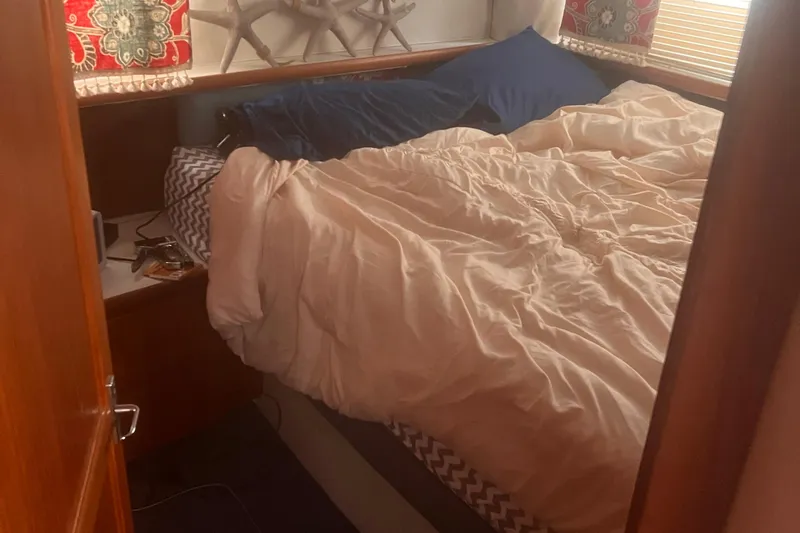 Slide: The Image of Cozy bedroom interior in a 1994 Carver 350 boat with decorative pillows and bedding. - 43