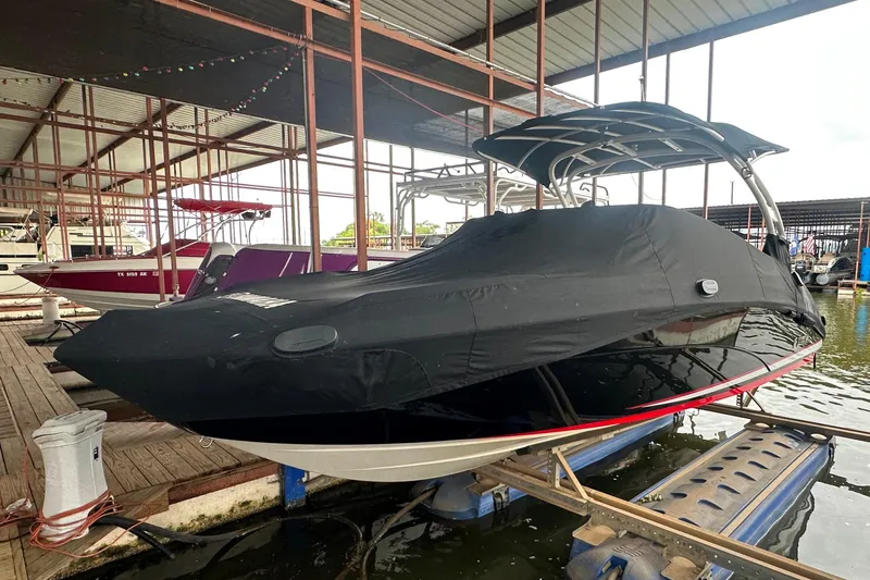 Slide: The Image of 2020 Yamaha Boats 242SE covered, docked in a marina with protective canopy. - 36