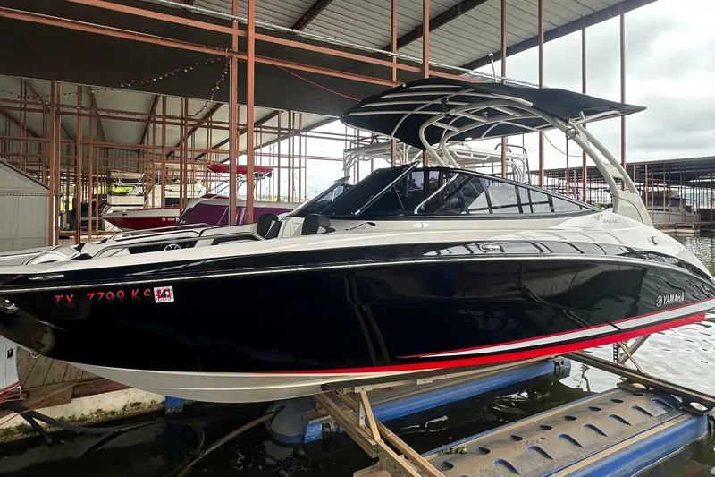 Slide: The Image of 2020 Yamaha Boats 242SE in dock, sleek black design with red accents. - 4
