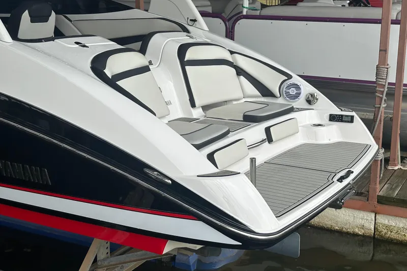 Slide: The Image of 2020 Yamaha Boats 242SE with sleek seating and modern design at a dock. - 6