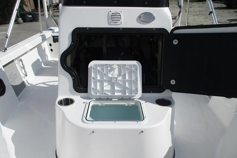 Slide: The Image of 2026 Sea Pro 210 Bay boat interior with open storage compartment and cup holders. - 16