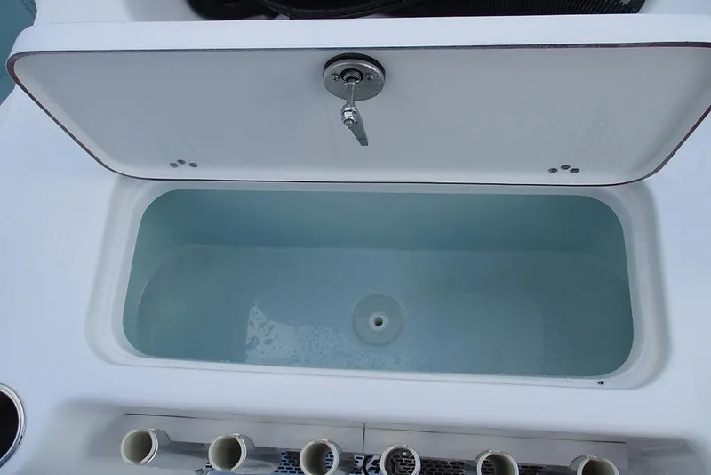 Slide: The Image of Livewell compartment on a 2026 Sea Pro 210 Bay boat, open lid view. - 19