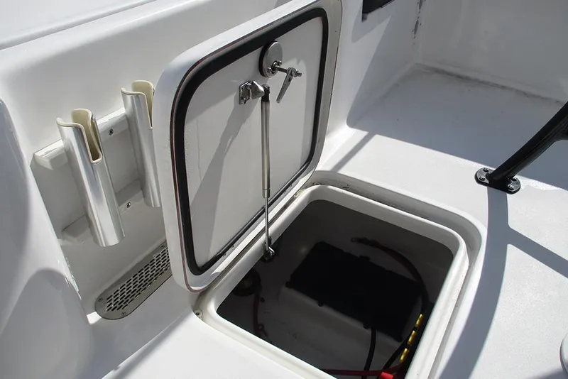 Slide: The Image of 2026 Sea Pro 210 Bay boat storage compartment with open hatch and rod holders. - 23
