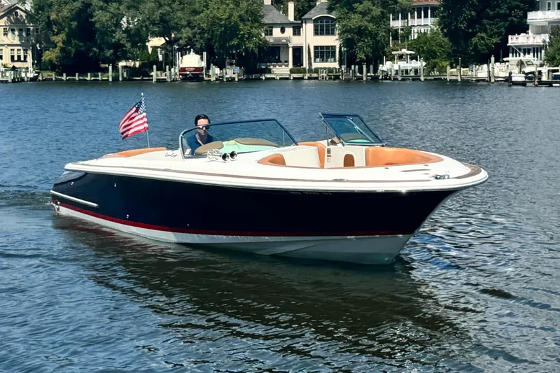 Slide: The Image of 2008 Chris-Craft Launch 28 boat cruising on a serene lake with American flag. - 1