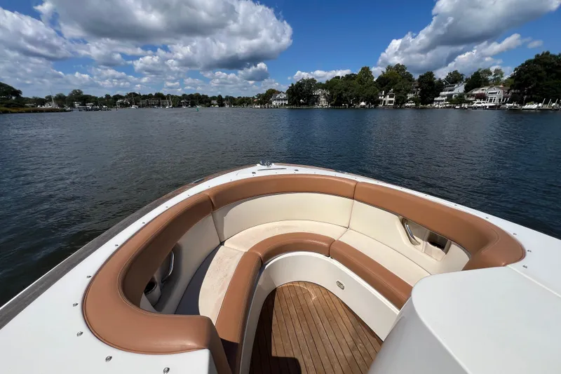 Slide: The Image of 2008 Chris-Craft Launch 28 boat with tan seating, on a serene lake under blue skies. - 15