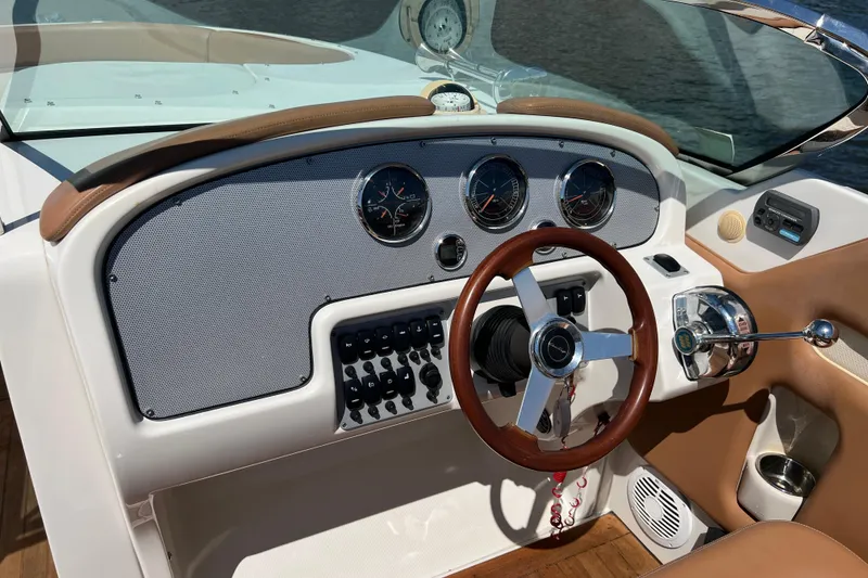 Slide: The Image of 2008 Chris-Craft Launch 28 boat dashboard with wooden steering wheel and control panel. - 17