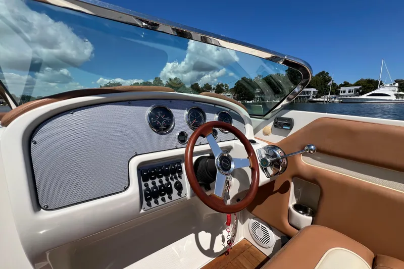 Slide: The Image of 2008 Chris-Craft Launch 28 dashboard with steering wheel, gauges, and waterfront view. - 18
