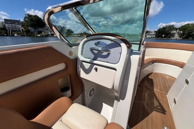 Slide: The Image of 2008 Chris-Craft Launch 28 boat interior with tan leather seats and wooden flooring. - 19