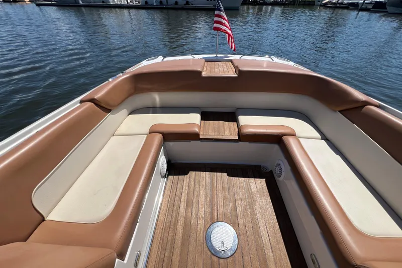 Slide: The Image of 2008 Chris-Craft Launch 28 boat interior with cushioned seating and American flag. - 25