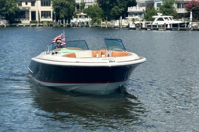 Slide: The Image of 2008 Chris-Craft Launch 28 boat cruising on a scenic waterfront. - 4