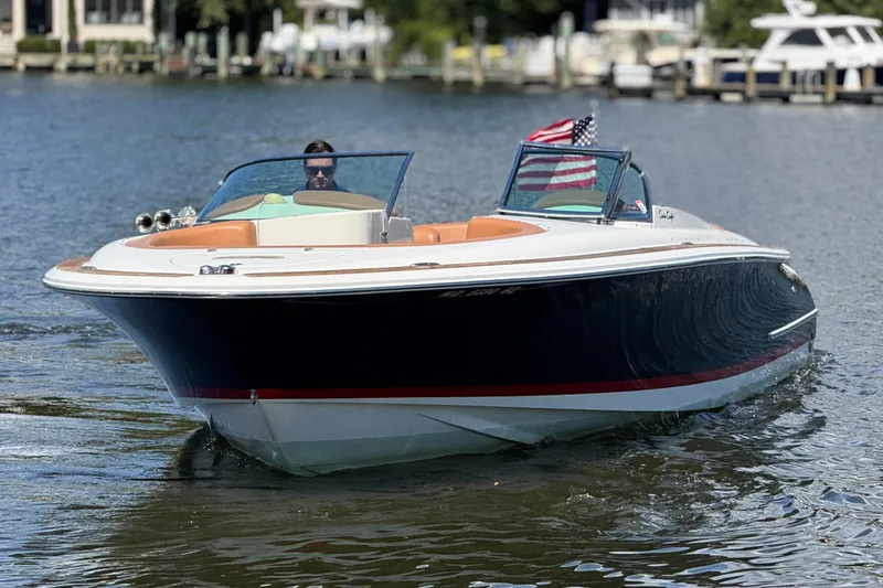 Slide: The Image of 2008 Chris-Craft Launch 28 boat cruising on a calm lake with American flag. - 6