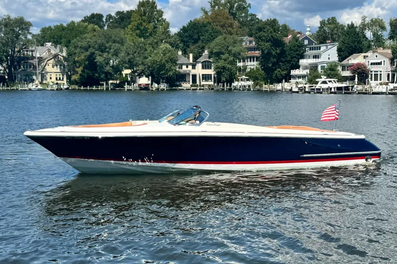 Slide: The Image of 2008 Chris-Craft Launch 28 boat on a serene lake with waterfront homes in the background. - 7