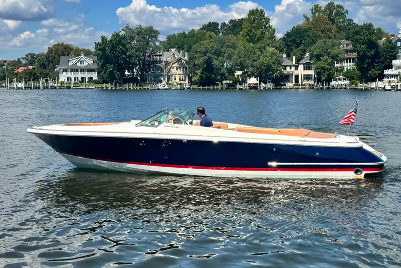 Slide: The Image of 2008 Chris-Craft Launch 28 boat cruising on a scenic river with waterfront homes. - 9