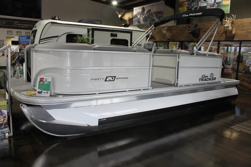 The Image of 2026 Sun Tracker Party Barge 20 DLX pontoon boat displayed indoors. - 1