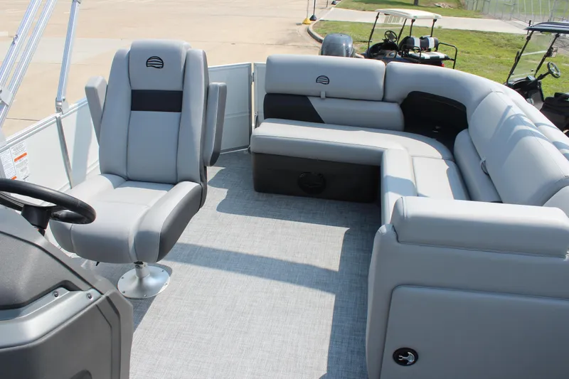 Slide: The Image of 2026 Sun Tracker Party Barge 20 DLX interior with gray seating and steering console. - 13