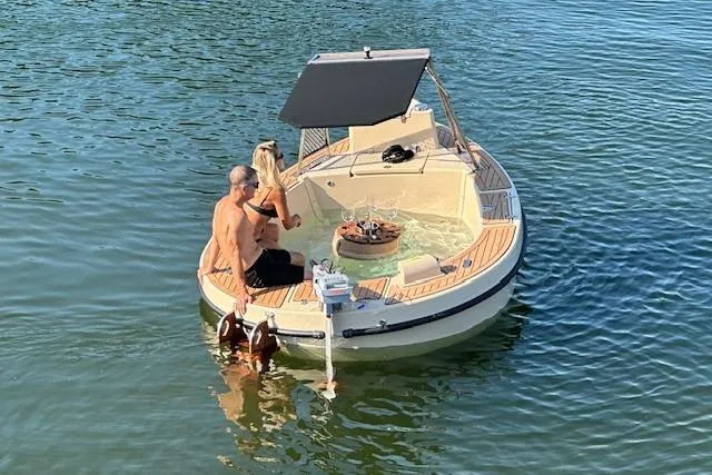 Slide: The Image of Couple enjoying a 2022 Spacruzzi V-1 boat with hot tub on a sunny day. - 7