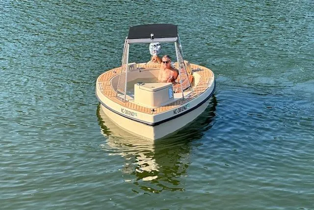 Slide: The Image of 2022 Spacruzzi V-1 boat on water with two people relaxing onboard. - 8