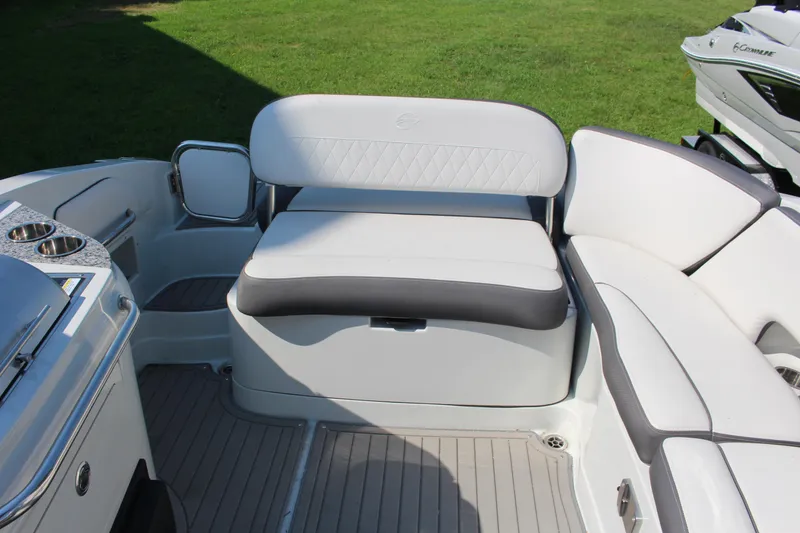 Slide: The Image of 2023 Crownline E285 boat interior with white cushioned seating and cup holders. - 13