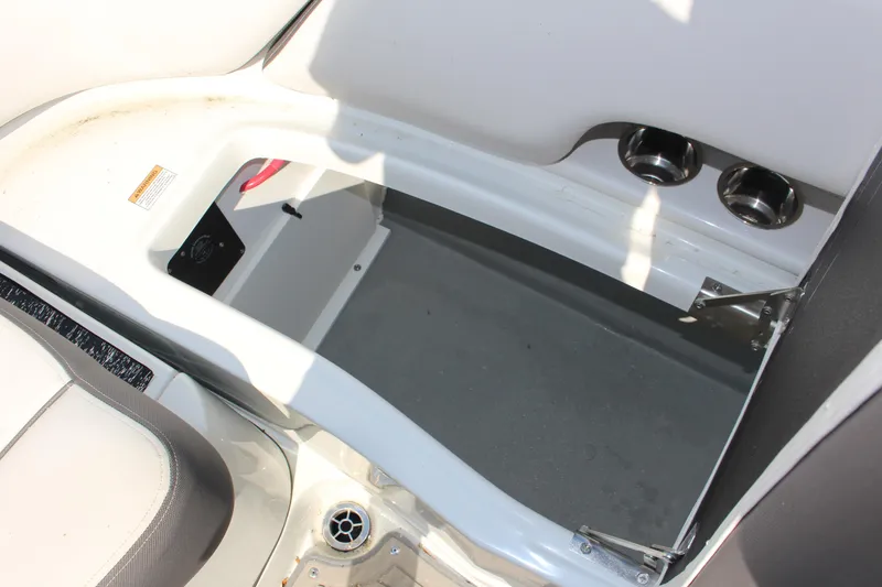Slide: The Image of 2023 Crownline E285 boat interior with storage compartment and cup holders. - 16