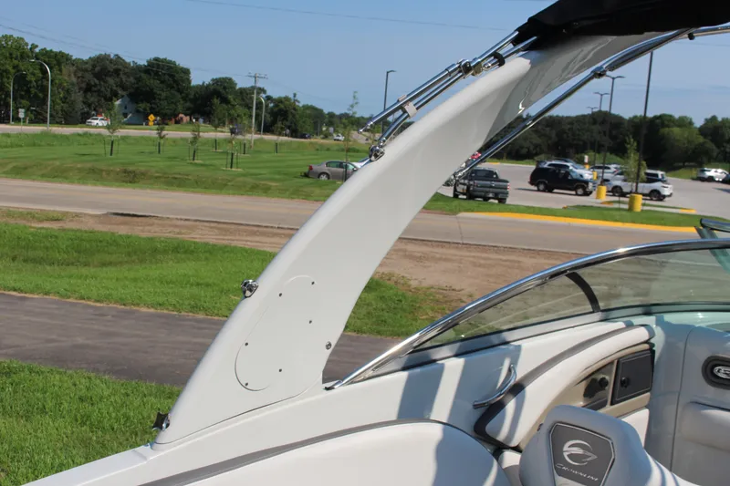 Slide: The Image of 2023 Crownline E285 boat with sleek design and modern interior, parked near a road. - 20