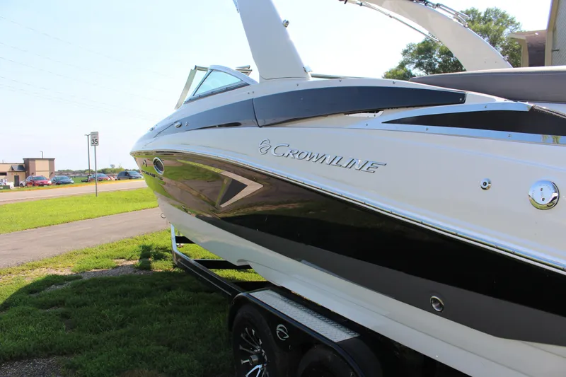 Slide: The Image of 2023 Crownline E285 boat on trailer, side view, outdoors. - 24