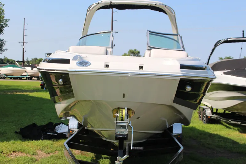 Slide: The Image of 2023 Crownline E285 boat on trailer, front view, parked on grass. - 28