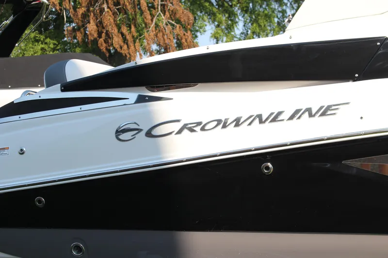 Slide: The Image of 2023 Crownline E285 boat side view with logo, featuring sleek black and white design. - 31