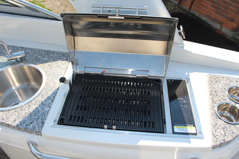 Slide: The Image of Outdoor grill and sink on 2023 Crownline E285 boat, featuring granite countertop. - 38