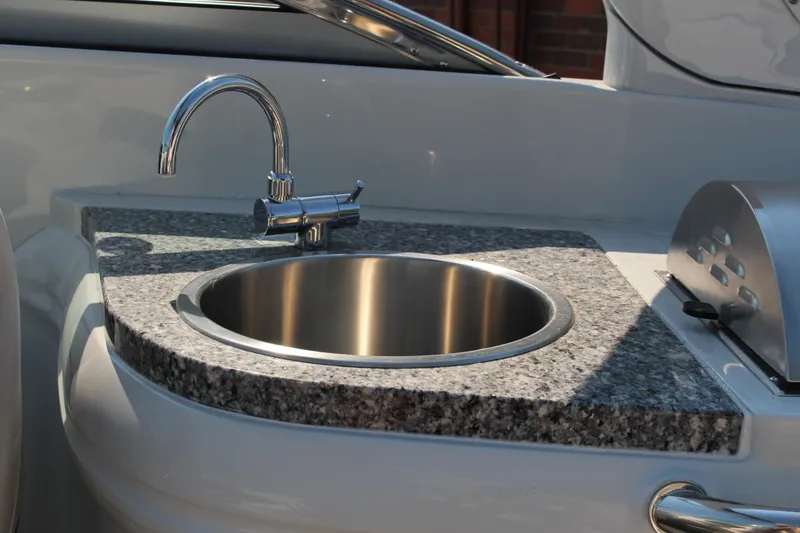 Slide: The Image of 2023 Crownline E285 boat with granite countertop and stainless steel sink. - 42