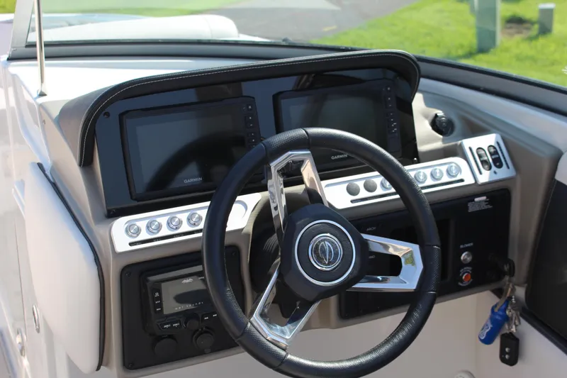 Slide: The Image of 2023 Crownline E285 boat dashboard with steering wheel and navigation displays. - 43