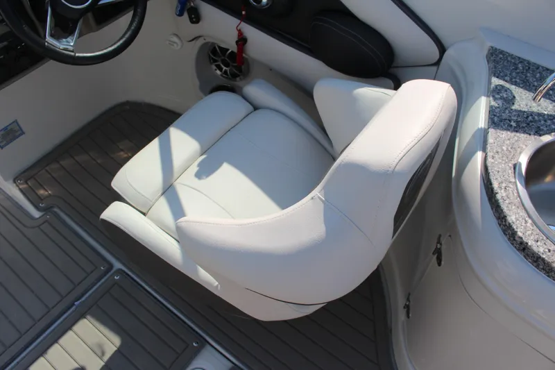 Slide: The Image of 2023 Crownline E285 boat interior with white captain's chair and granite countertop sink. - 45