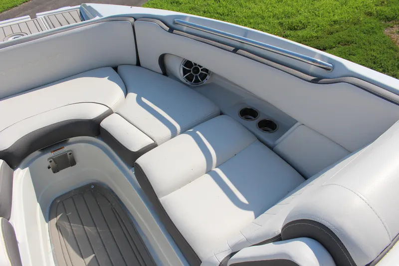 Slide: The Image of 2023 Crownline E285 boat interior with cushioned seating and cup holders. - 48