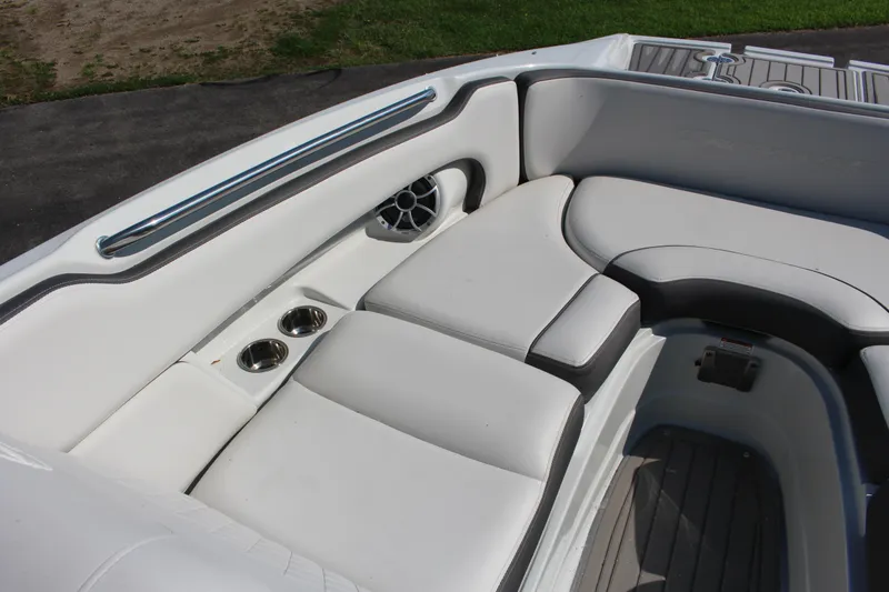 Slide: The Image of 2023 Crownline E285 boat interior with white cushioned seating and cup holders. - 49